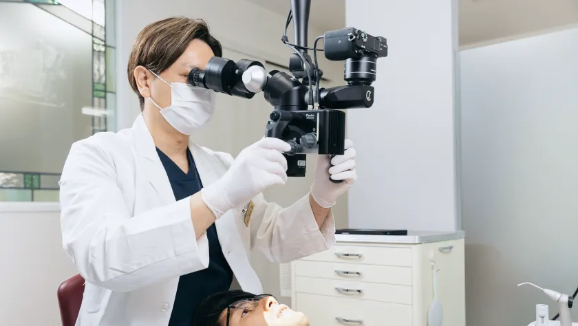 精密な機器を用いて、患者さんの歯を精密に観察する歯科医。