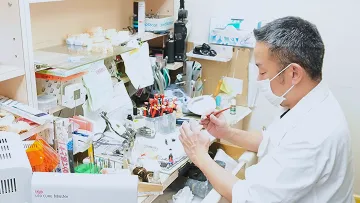 緻密な作業に没頭する熟練の技師。