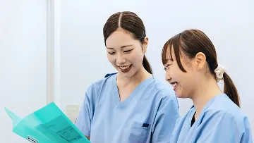 明るい笑顔で、医療記録を共有する二人の若い女性。